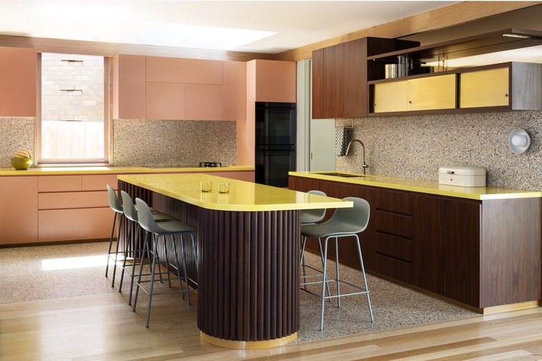 The colorful kitchen features a banana yellow island.