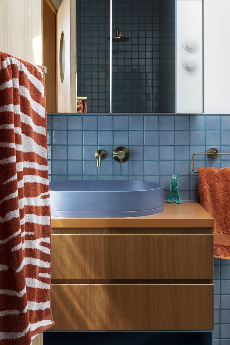 blue kids bathroom with wood vanity cabinet