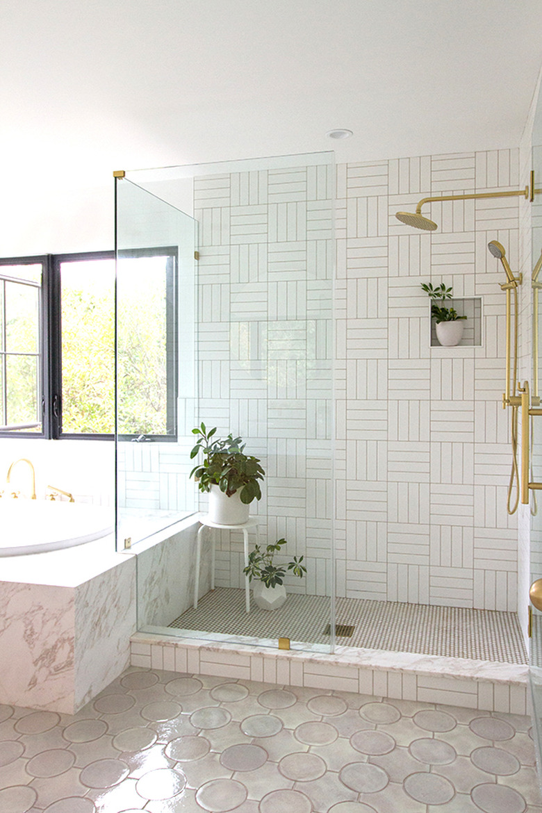 walk-in shower with potted plants and white patterned tile