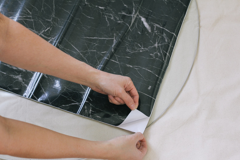 Peeling back corner of contact paper