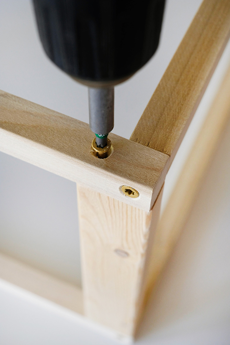 Place the screw in about 1 inch from the corner to prevent hitting the screw that is already in place.