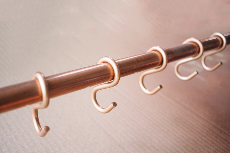 S hooks hanging on copper pipe