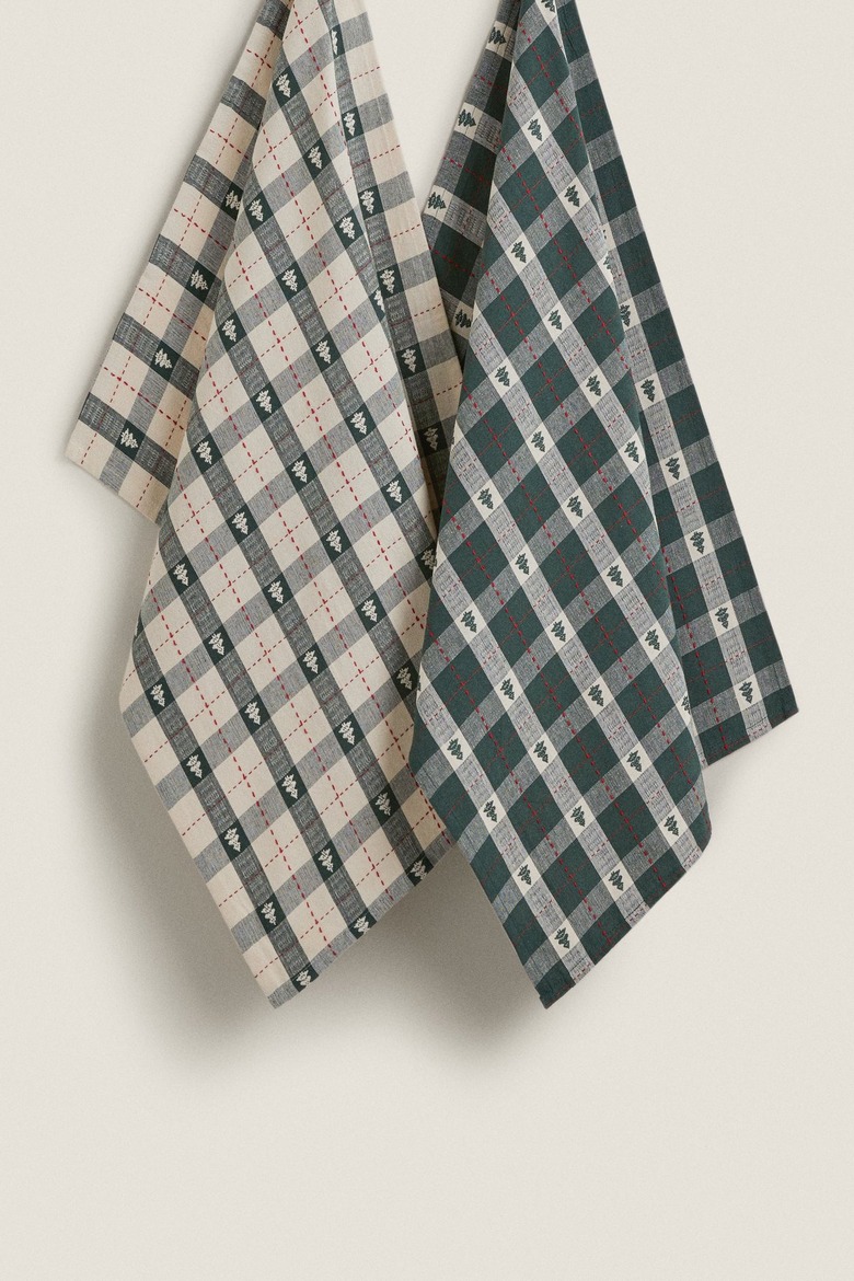 Two green and white Christmas kitchen towels with plaid designs and tiny Christmas trees on them.