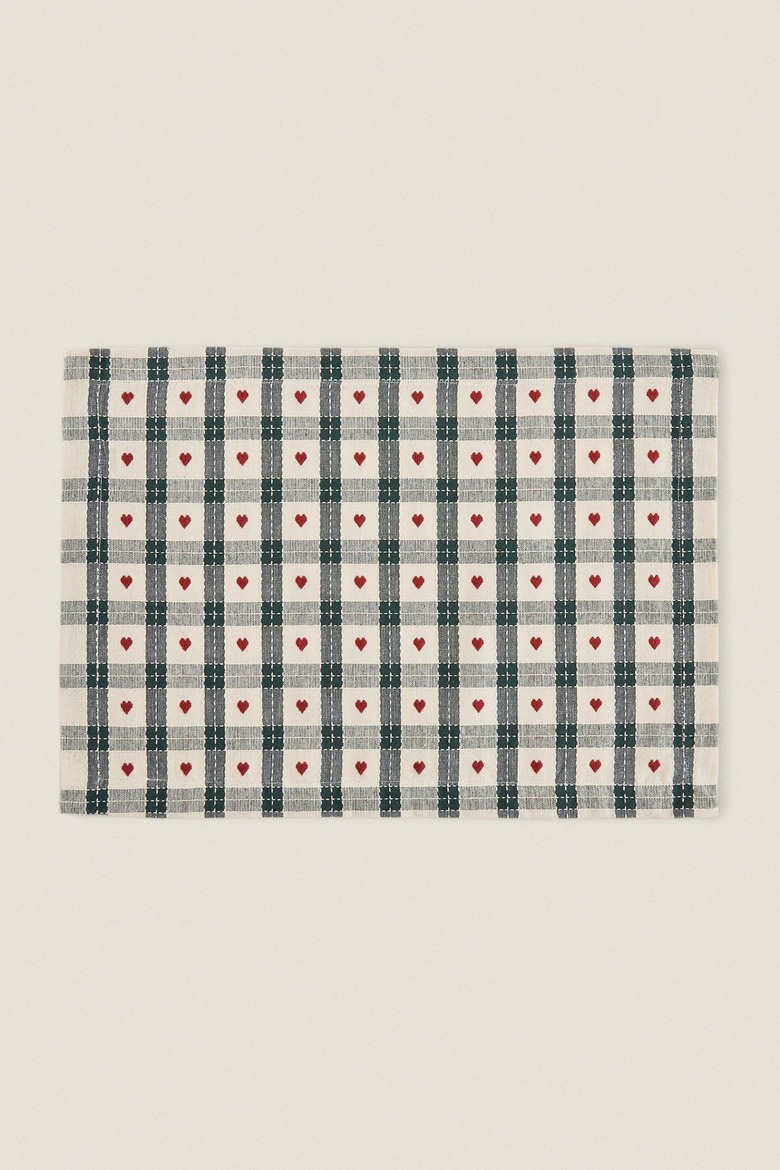 A placemat featuring a green plaid pattern with red hearts in the white spaces.