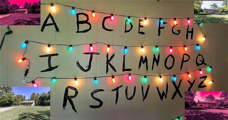 A wall painted with the alphabet with Christmas lights strung up onto it