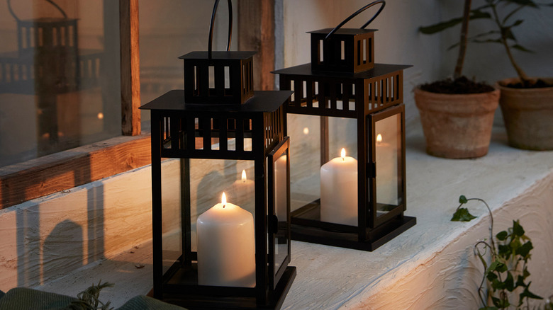 A pair of IKEA lanterns on a ledge near a window