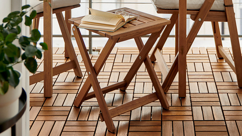 A warm brown outdoor folding stool by other brown pieces of furniture