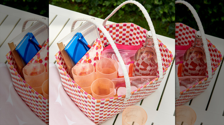A colorful picnic basket full of food and drink items
