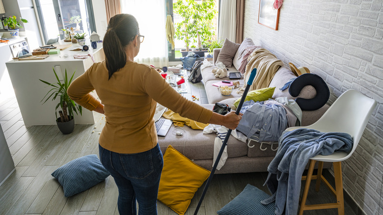 A person overlooking the clutter in a small, messy living space