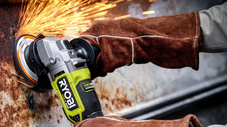 Person wearing heavy gloves using an angle grinder to clean metal