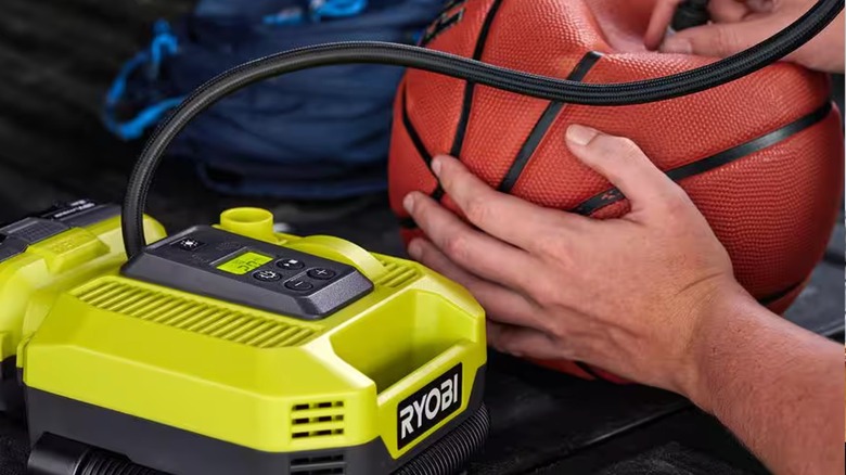 Person pumping up basketball with a Ryobi Inflator