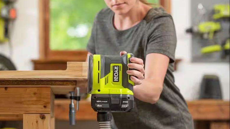 Woman sanding woodwork with Ryobi Sander