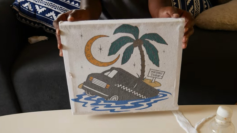 A vintage Vans t-shirt featuring a van sinking in the ocean by an island, stretched over a frame