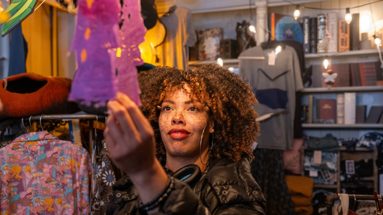 Young woman thrifting vintage clothes