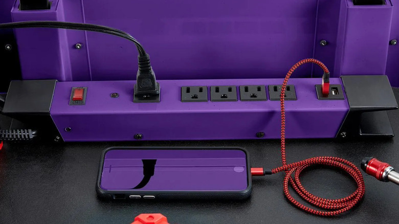 a three-pronged cord and USB charger plugged into a bright purple power strip