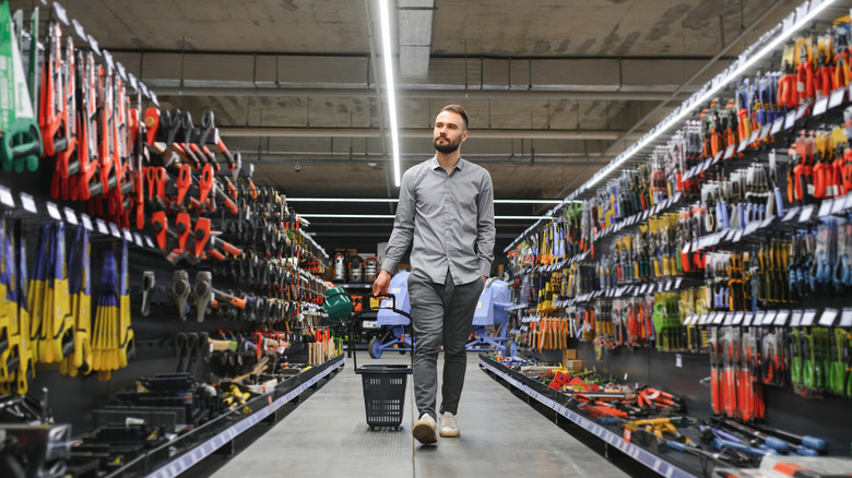 a man walks through an aisle at a hardware store