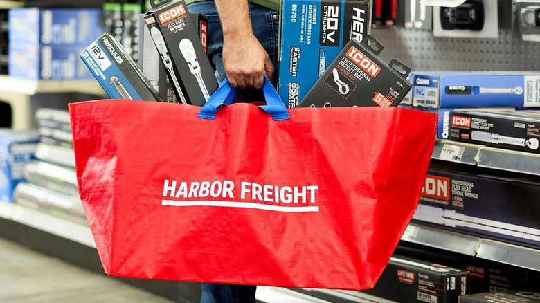 a man holds a large red bag full of Harbor Freight tools