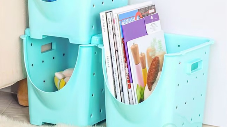 Books and small items are stored in three blue plastic decorative bins