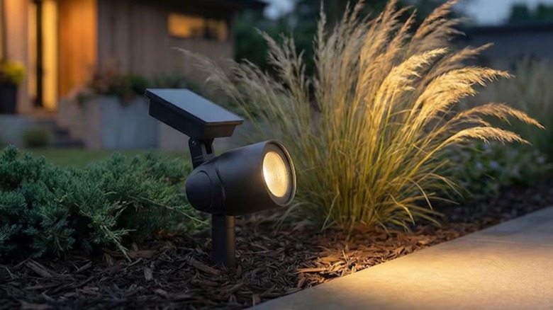 A warm solar light illuminates an outdoor walkway at dusk