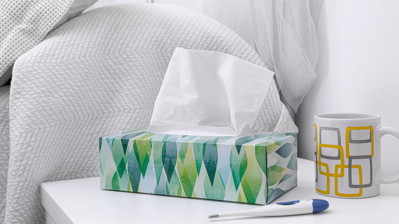 Printed box of tissues with thermometer on nightstand