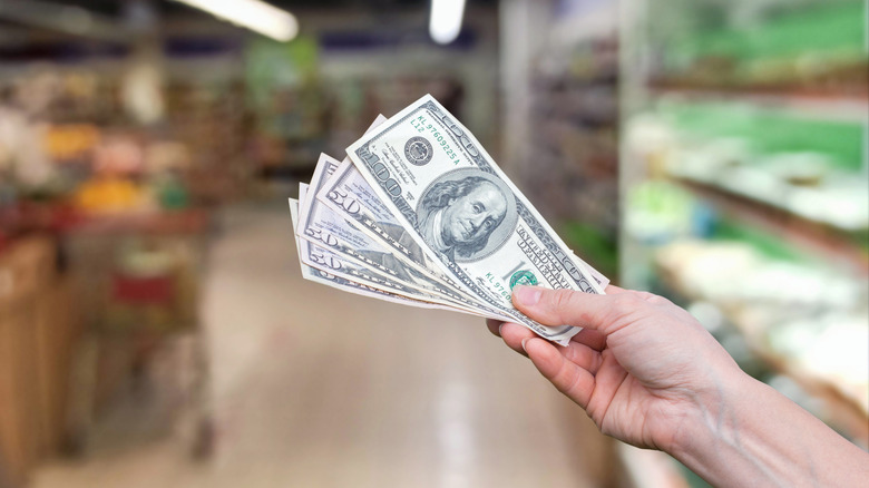 Hand holding cash in Dollar Store