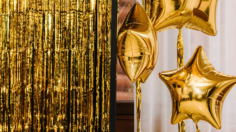 Two hands holding a gold foil star balloon