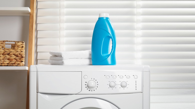 Blue bottle of fabric softener atop a washing machine
