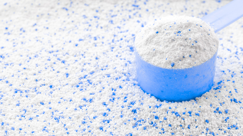 Measuring cup on a pile of laundry detergent powder