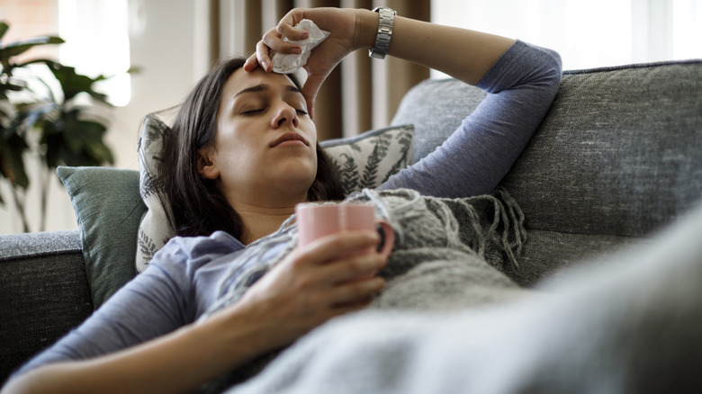 sick woman laying on couch