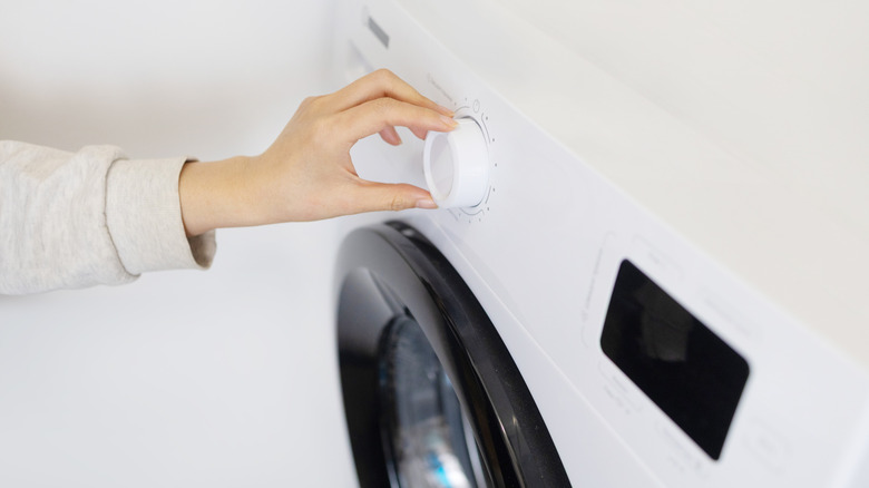 woman setting washer control dial