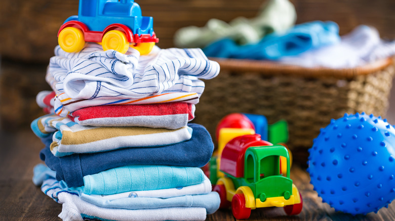 stack of baby clothes and toys