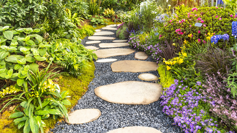A path leading through a garden with colorful flowers in purples, yellows, and pinks