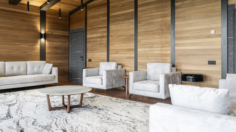 a rustic modern living room with a marble table, marble style rug, and matching gray chairs and sofa