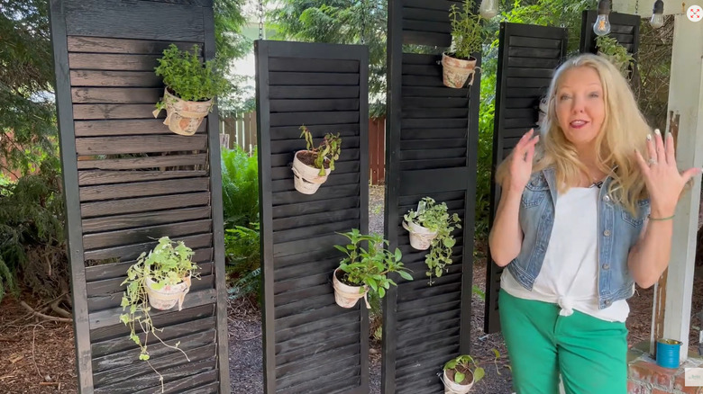 Creator shows off her hanging shutters with plants hanging on them