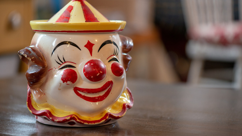 Close up of vintage clown cookie jar on wood table