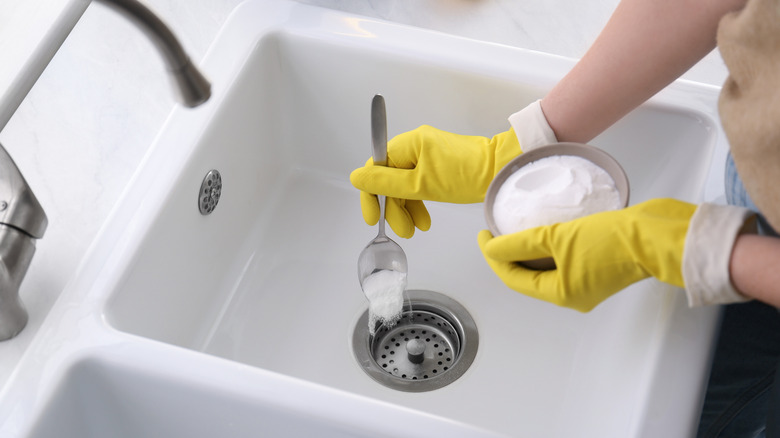a person uses natural products to unclog a drain