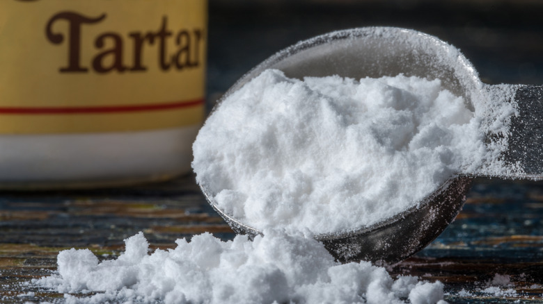 close up cream of tartar teaspoon and container in background