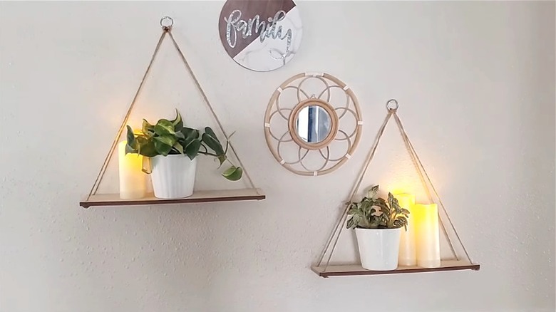 Hanging dollar store shelves on hooks with plants and LED candles