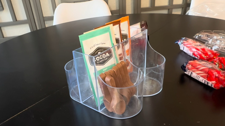 Clear cutlery organizer on dining table with hot cocoa, spoons, and accessories