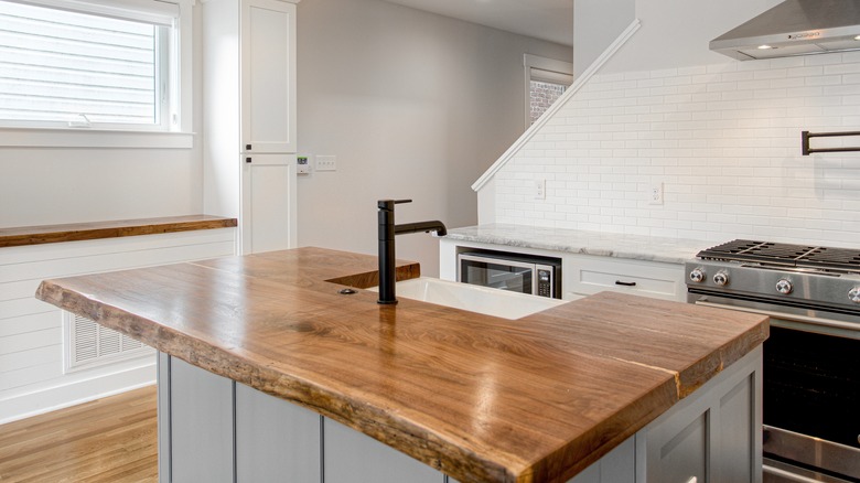 a kitchen island with natural raw wood edge countertop