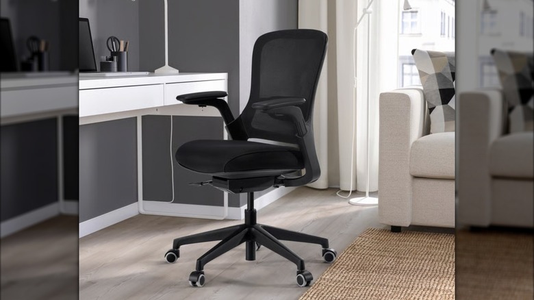 A black CENTERHALV office chair from IKEA sits in front of a white desk
