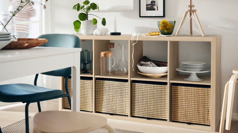 Plants, plates, and decorative items are stored on a KALLAX shelf unit from IKEA
