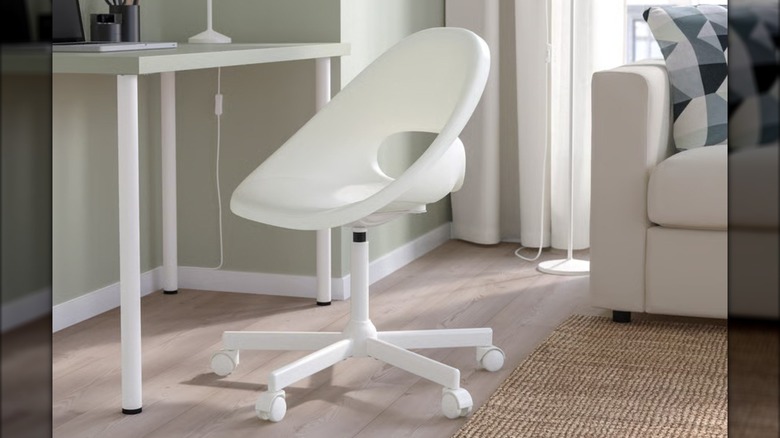 A modern white swivel chair from IKEA sits in a neutral living room