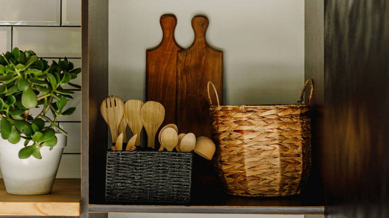 open shelf with storage baskets and cutting boards