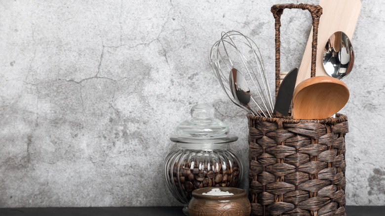 woven basket with handle used to hold kitchen utensils