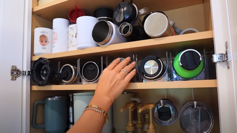 An open cabinet filled with drinkware.
