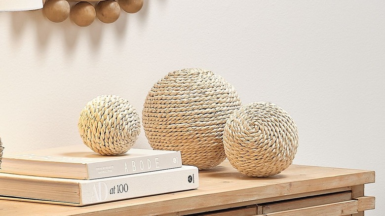 Woven braided spheres freestanding on console tabletop with coffee table books
