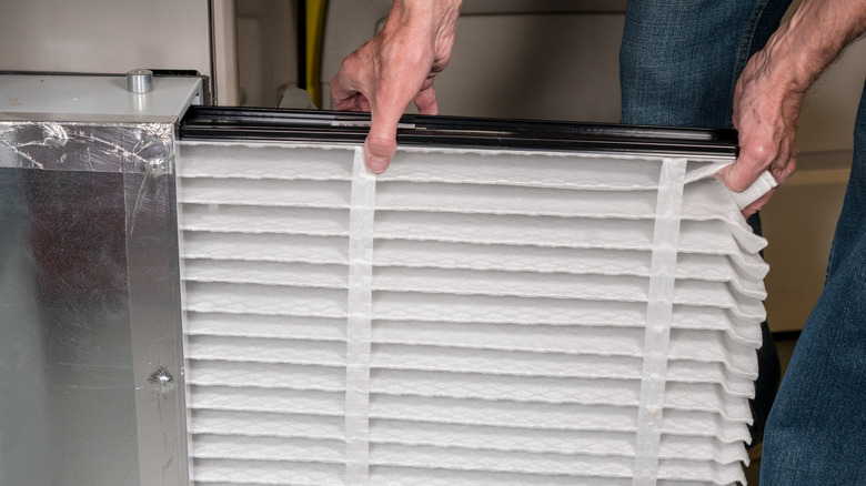 A homeowner replaces an HVAC air filter