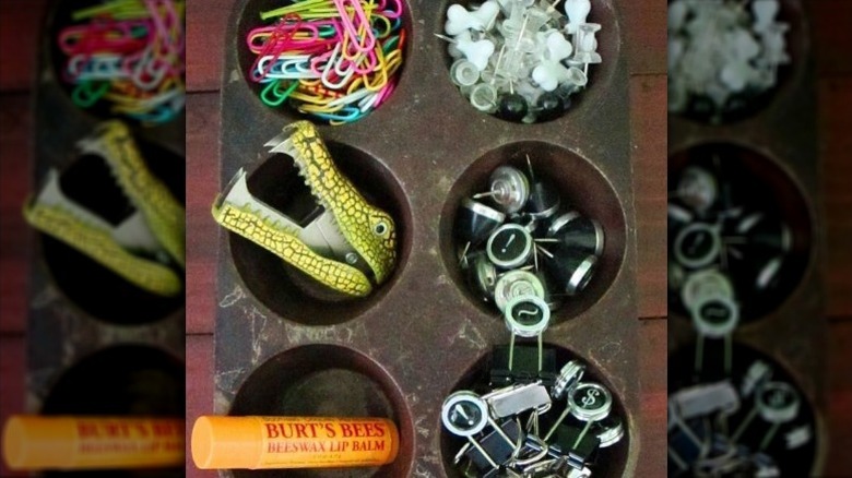 Office supplies sorted in rusty muffin tin