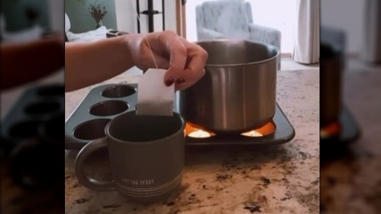 Small pot of water being heated by tea lights in muffin tin